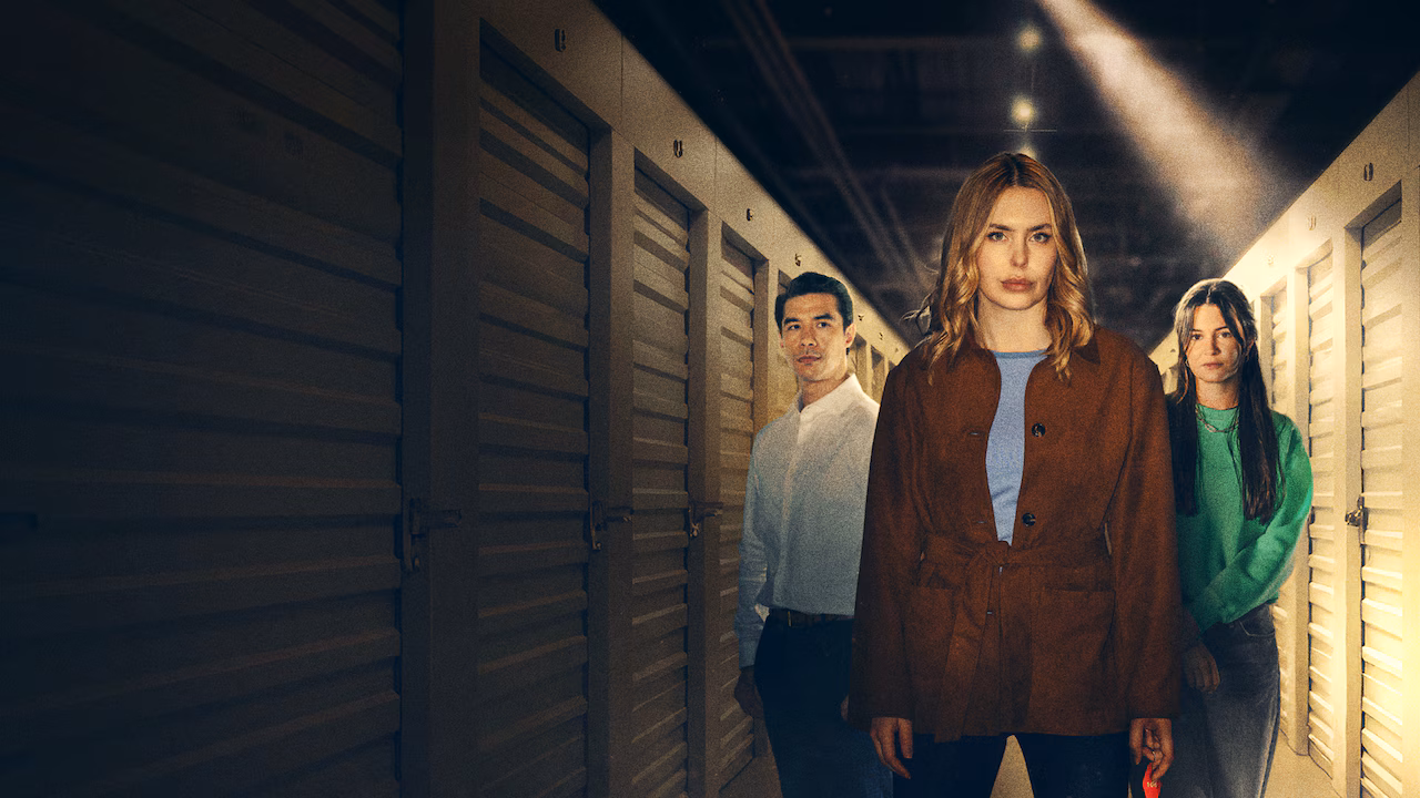Kirsten Comerford, Chris Hong, and Jayne Heitmeyer standing in a dimly lit storage locker corridor in The Body in the Locker